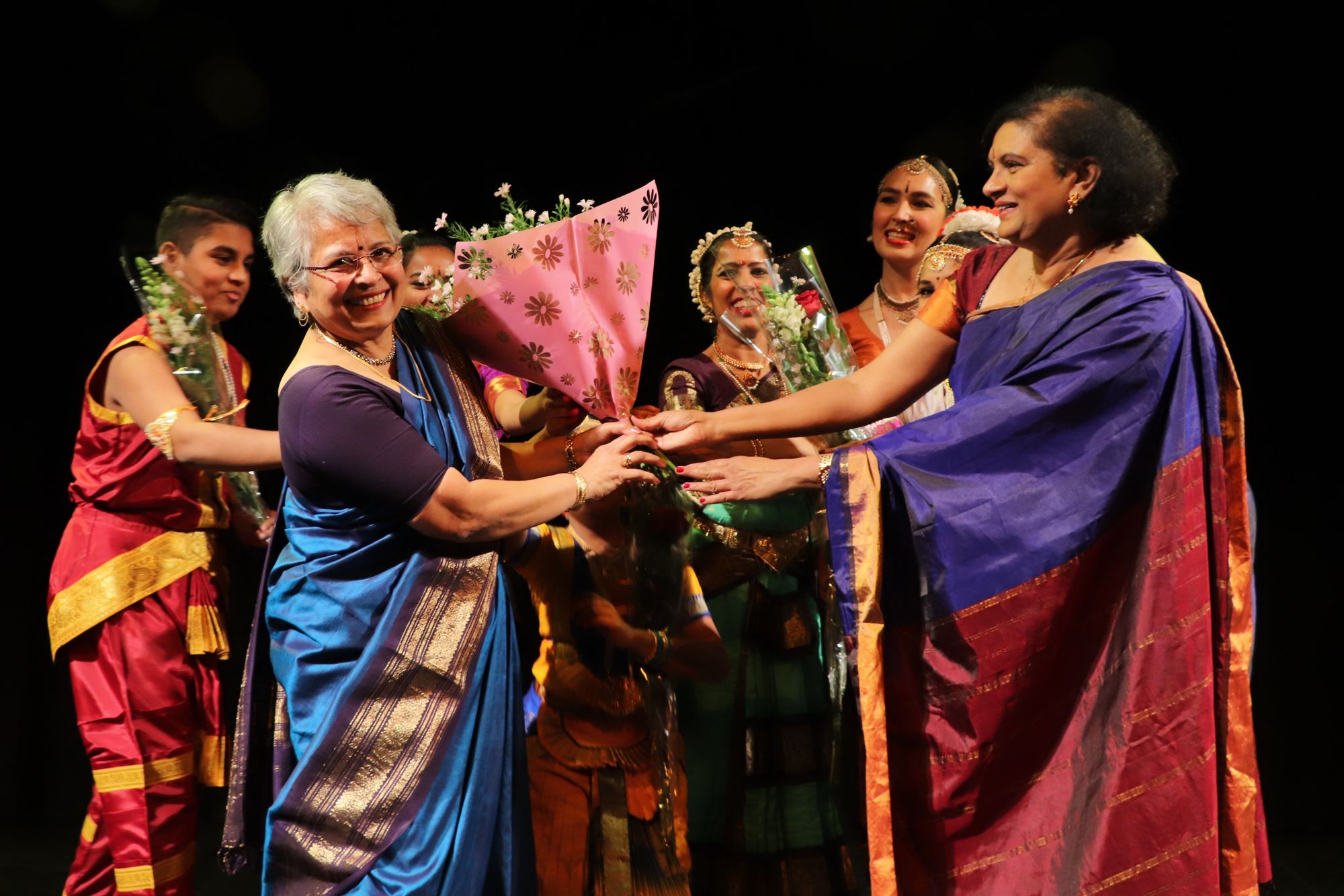 Na de voorstelling krijgt guru Chandrika Sundararaman bloemen van de dansers op het podium