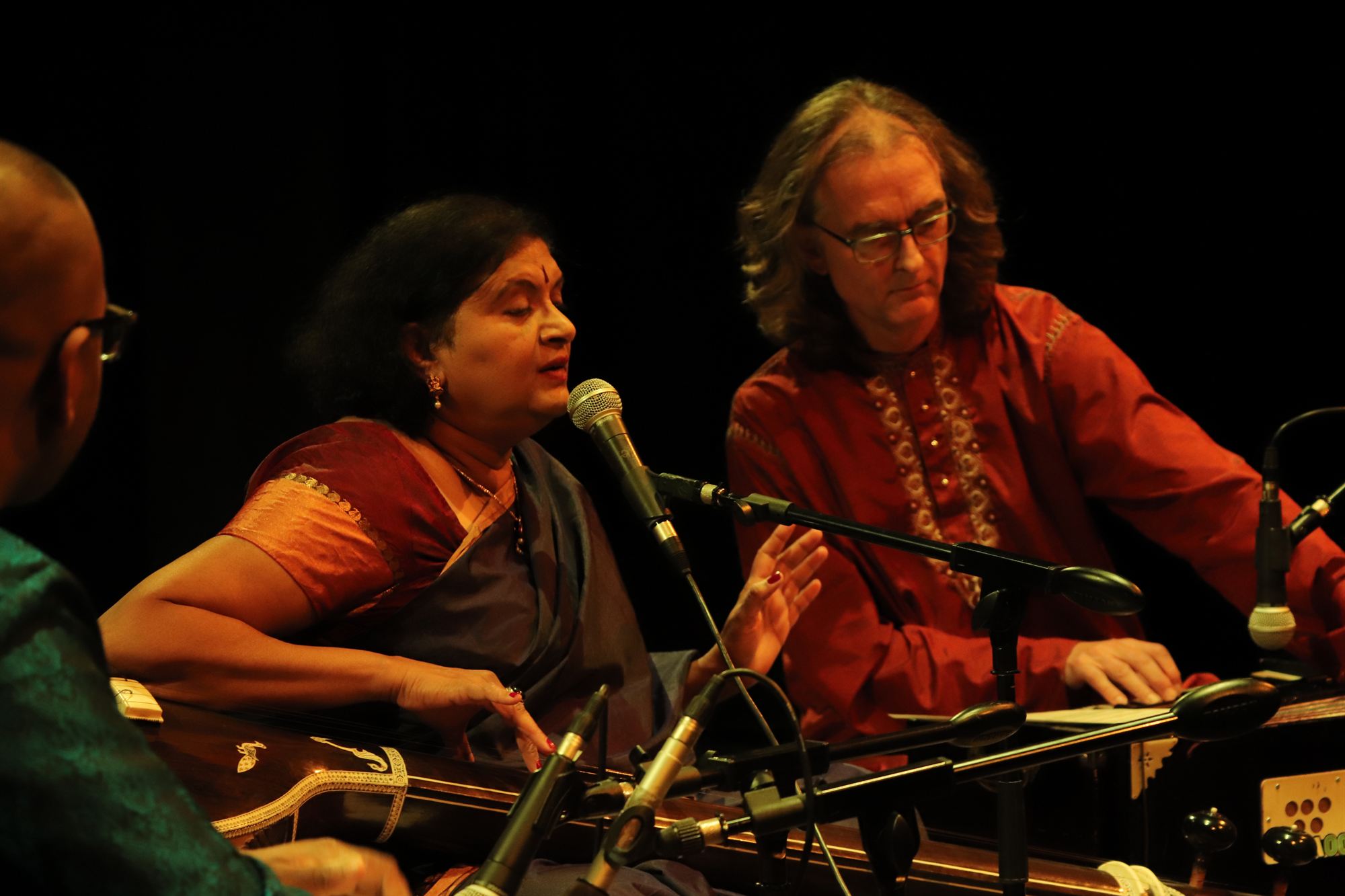 Vocalist at the harmonium during a concert, with accompaniment