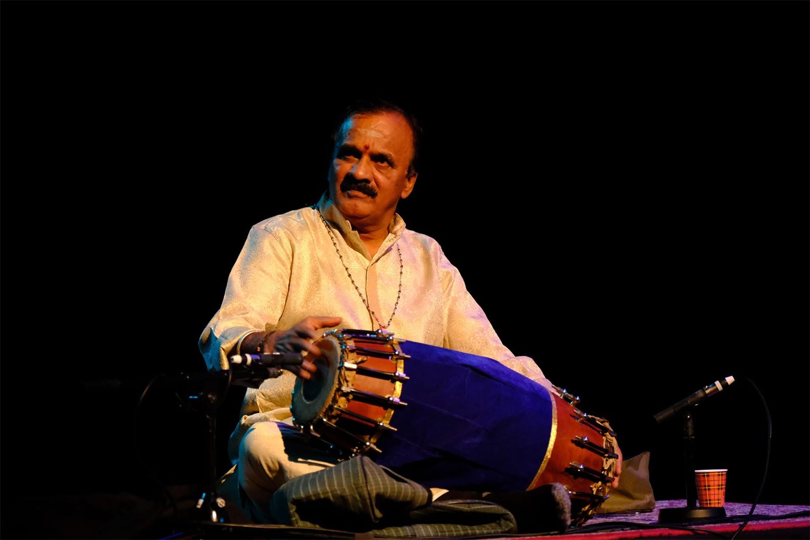Vidwan Sri S.V. Giridhara playing the mridangam on stage
